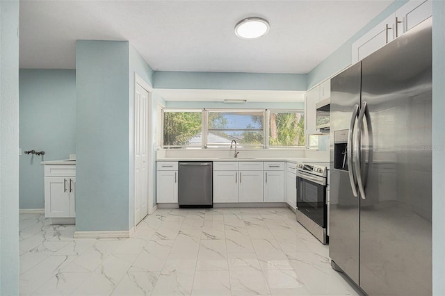 801 Lamont Pl, Temple Terrace, FL 33617 - kitchen featuring appliances with stainless steel finishes, light marble finish floors, white cabinets, and light countertops