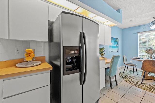 10032 Basin St, New Port Richey, FL 34655 - kitchen featuring stainless steel refrigerator with ice dispenser, white cabinetry, light tile patterned floors, light countertops, and decorative backsplash