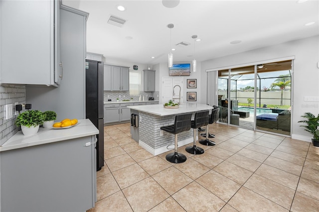 1601 Fox Grape Loop, Lutz, FL 33558 - kitchen featuring gray cabinets, freestanding refrigerator, backsplash, plenty of natural light, and recessed lighting