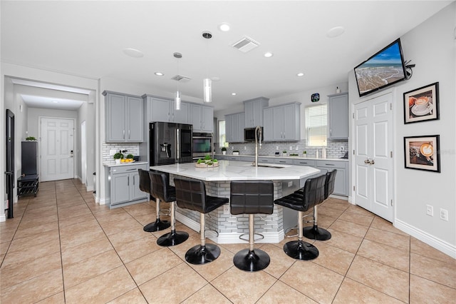 1601 Fox Grape Loop, Lutz, FL 33558 - kitchen with gray cabinetry, decorative backsplash, a breakfast bar area, light tile patterned floors, and decorative light fixtures