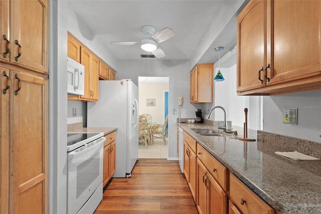 2875 Lomond Dr, Palm Harbor, FL 34684 - kitchen with white appliances, a ceiling fan, wood finished floors, dark stone countertops, and decorative light fixtures