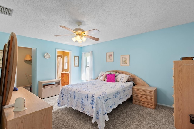 2875 Lomond Dr, Palm Harbor, FL 34684 - carpeted bedroom featuring a walk in closet, ceiling fan, a textured ceiling, a closet, and ensuite bathroom