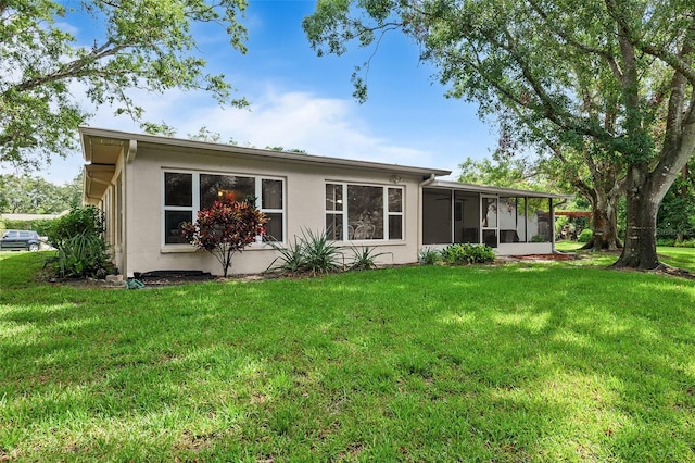 2875 Lomond Dr, Palm Harbor, FL 34684 - rear view of house featuring a sunroom, a lawn, and stucco siding