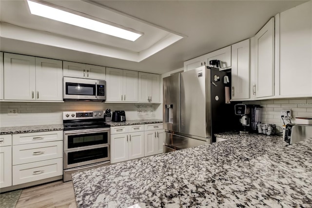 7320 Hideaway Trl, New Port Richey, FL 34655 - kitchen with appliances with stainless steel finishes, light stone counters, and white cabinets
