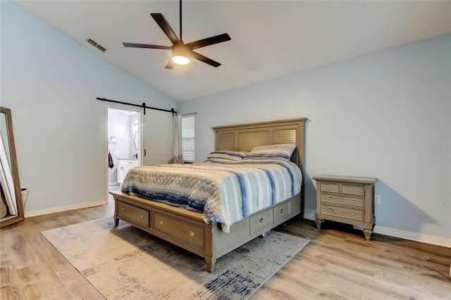 7320 Hideaway Trl, New Port Richey, FL 34655 - bedroom featuring light wood-style floors, vaulted ceiling, a barn door, and a ceiling fan