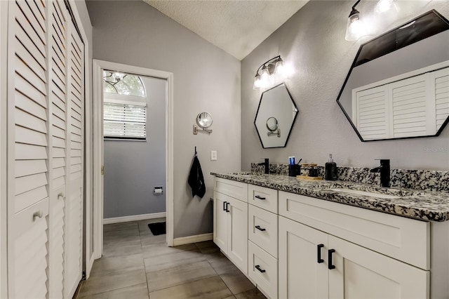 7320 Hideaway Trl, New Port Richey, FL 34655 - bathroom with lofted ceiling, double vanity, tile patterned floors, a closet, and a textured ceiling