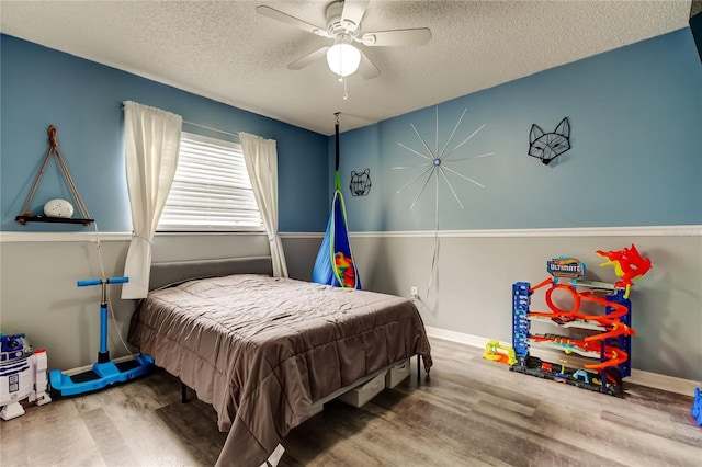 7320 Hideaway Trl, New Port Richey, FL 34655 - bedroom featuring wood finished floors, a textured ceiling, and a ceiling fan