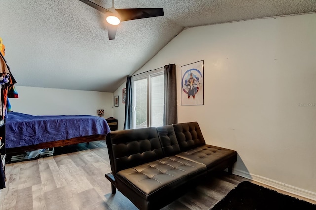 7320 Hideaway Trl, New Port Richey, FL 34655 - bedroom featuring a textured ceiling, vaulted ceiling, wood finished floors, and a ceiling fan