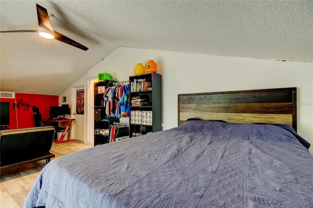 7320 Hideaway Trl, New Port Richey, FL 34655 - bedroom with wood finished floors, vaulted ceiling, a textured ceiling, ceiling fan, and an office area