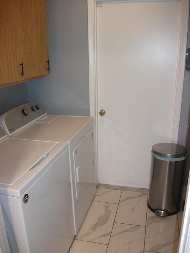 12411 Brookside St, Spring Hill, FL 34609 - laundry area featuring cabinet space, washing machine and clothes dryer, and light marble finish floors