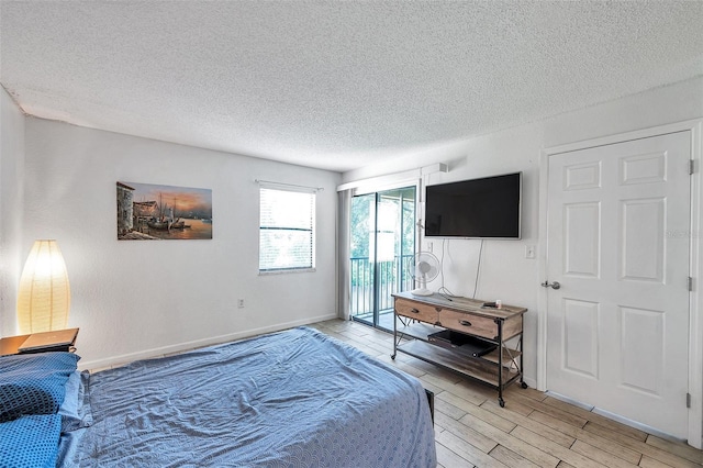 10195 Sailwinds Blvd N Unit 208, Largo, FL 33773 - bedroom featuring a textured ceiling, access to exterior, and light wood finished floors