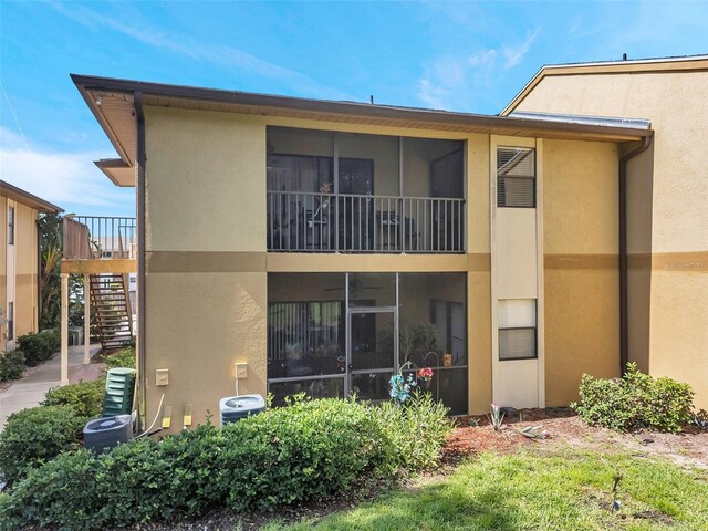 10195 Sailwinds Blvd N Unit 208, Largo, FL 33773 - back of house featuring stairs, stucco siding, and a sunroom