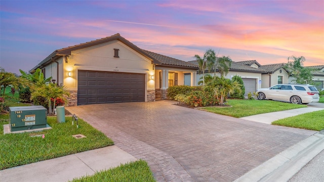 20828 Cattail Blvd, Venice, FL 34292 - single story home featuring decorative driveway, a garage, stone siding, a lawn, and stucco siding