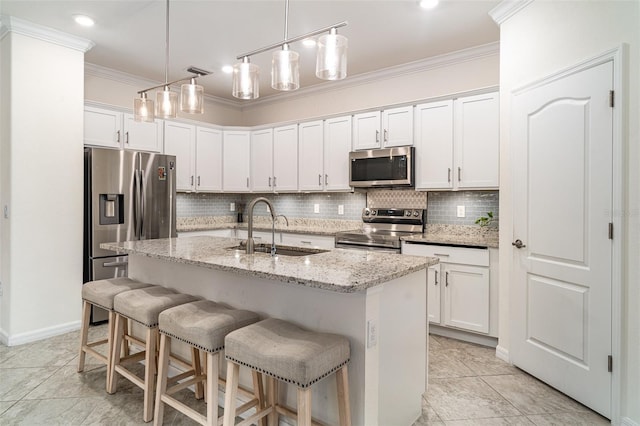20828 Cattail Blvd, Venice, FL 34292 - kitchen featuring appliances with stainless steel finishes, backsplash, crown molding, white cabinetry, and a breakfast bar area