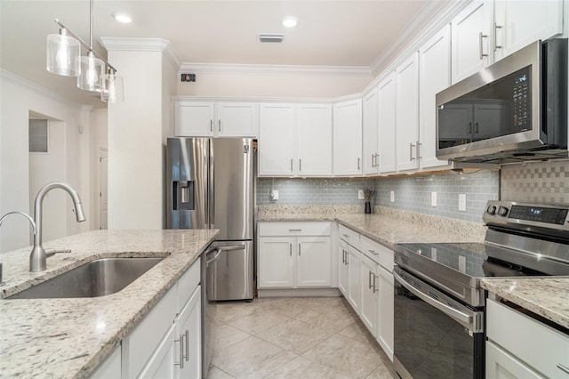 20828 Cattail Blvd, Venice, FL 34292 - kitchen featuring appliances with stainless steel finishes, crown molding, white cabinets, tasteful backsplash, and hanging light fixtures