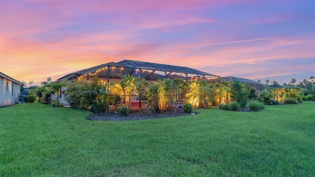 20828 Cattail Blvd, Venice, FL 34292 - back of property at dusk featuring a lawn and a lanai