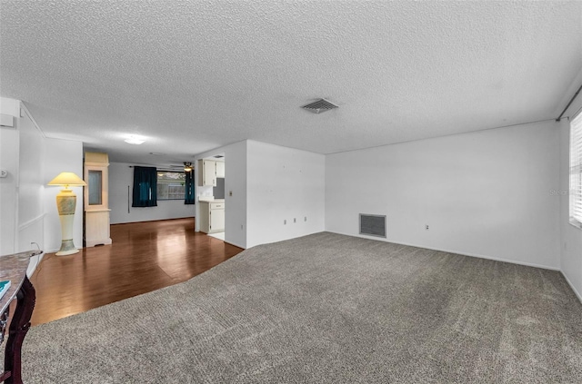 4143 Gray Squirrel Ln, New Port Richey, FL 34653 - unfurnished living room featuring dark carpet and a textured ceiling