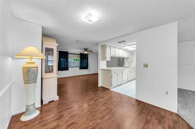 4143 Gray Squirrel Ln, New Port Richey, FL 34653 - unfurnished living room featuring ceiling fan, a textured ceiling, and light wood-style flooring