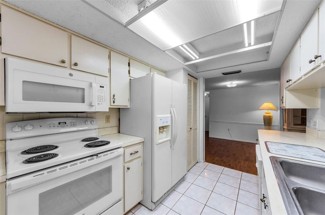 4143 Gray Squirrel Ln, New Port Richey, FL 34653 - kitchen with white appliances, light countertops, light tile patterned flooring, and decorative backsplash