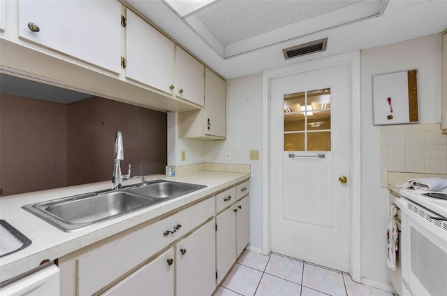 4143 Gray Squirrel Ln, New Port Richey, FL 34653 - kitchen with electric range, light countertops, light tile patterned floors, and white cabinetry