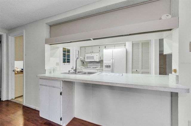 4143 Gray Squirrel Ln, New Port Richey, FL 34653 - kitchen featuring white appliances, a peninsula, dark wood-type flooring, and light countertops