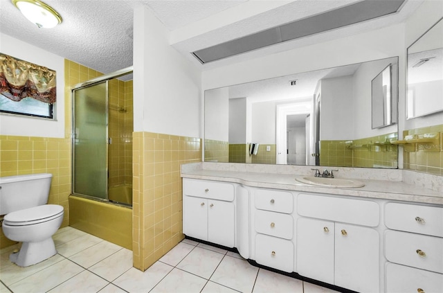 4143 Gray Squirrel Ln, New Port Richey, FL 34653 - bathroom with tile walls, tile patterned flooring, vanity, enclosed tub / shower combo, and a wainscoted wall