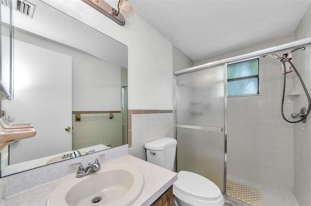 4143 Gray Squirrel Ln, New Port Richey, FL 34653 - bathroom with a stall shower, vanity, tile walls, a textured ceiling, and wainscoting