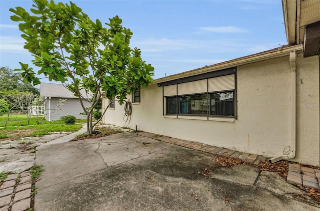 4143 Gray Squirrel Ln, New Port Richey, FL 34653 - view of side of property with stucco siding and a patio