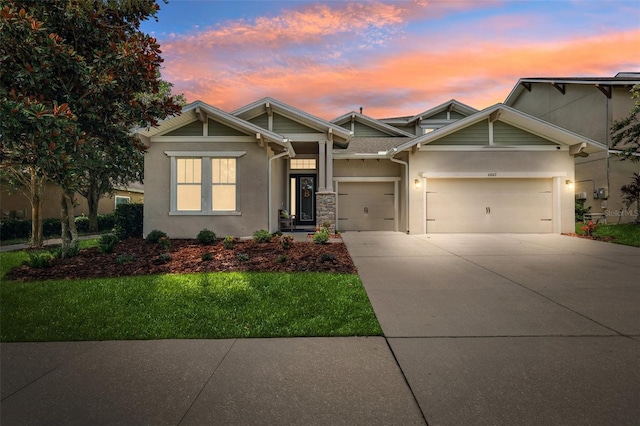 6007 Quartz Lake Way, Lithia, FL 33547 - craftsman-style home with stucco siding, an attached garage, concrete driveway, and a lawn