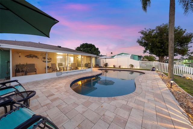 4252 Floramar Ter, New Port Richey, FL 34652 - pool at dusk with a patio and a fenced backyard