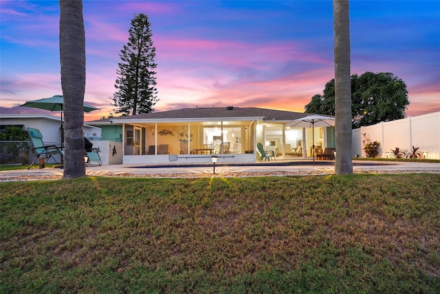 4252 Floramar Ter, New Port Richey, FL 34652 - back of house at dusk featuring a patio and a sunroom