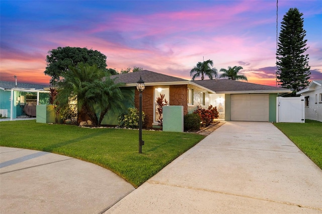 4252 Floramar Ter, New Port Richey, FL 34652 - ranch-style home featuring concrete driveway, stone siding, an attached garage, and a gate