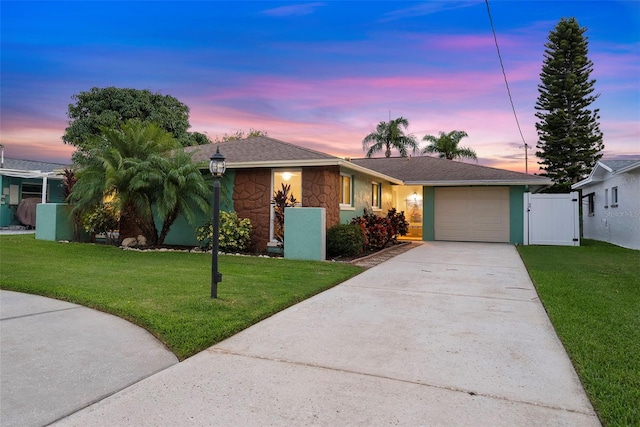 4252 Floramar Ter, New Port Richey, FL 34652 - single story home with an attached garage, concrete driveway, stone siding, a gate, and a shingled roof