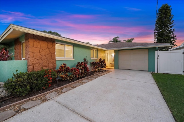 4252 Floramar Ter, New Port Richey, FL 34652 - ranch-style house with a garage, concrete driveway, stucco siding, and a gate