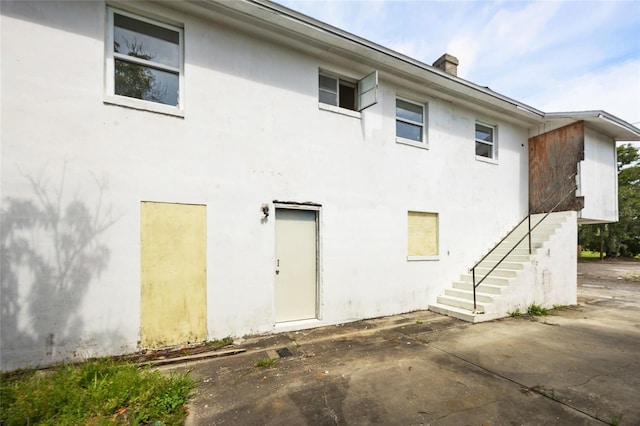 1919 Dr Martin Luther King Jr St S Unit J, Saint Petersburg, FL 33705 - back of property with stairway, stucco siding, a patio area, and a chimney