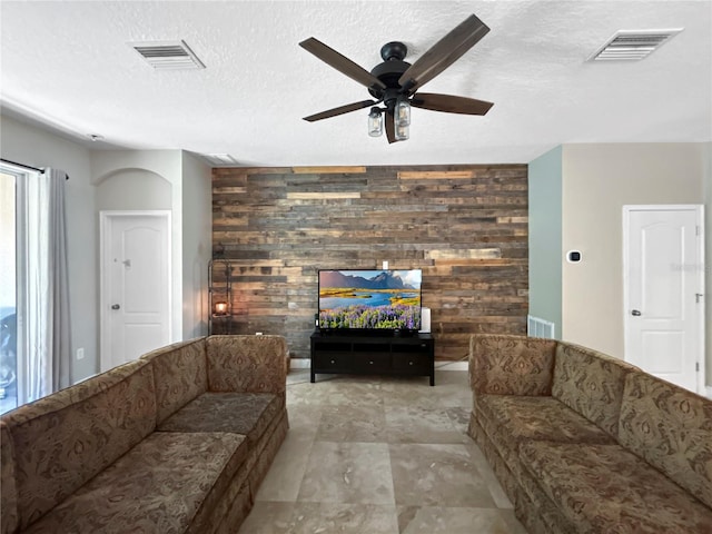 4079 Pacente Loop, Wesley Chapel, FL 33543 - living area featuring wood walls, ceiling fan, an accent wall, and a textured ceiling