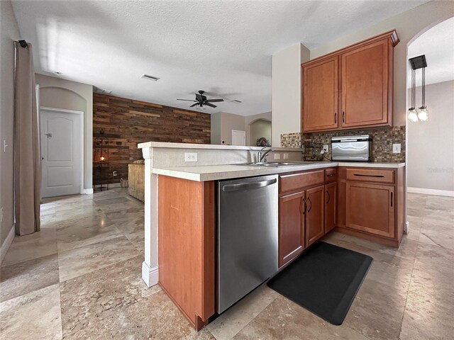 4079 Pacente Loop, Wesley Chapel, FL 33543 - kitchen featuring stainless steel dishwasher, ceiling fan, tasteful backsplash, arched walkways, and brown cabinetry