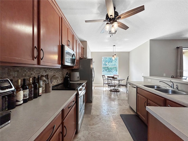 4079 Pacente Loop, Wesley Chapel, FL 33543 - kitchen featuring stainless steel appliances, backsplash, ceiling fan, light countertops, and a textured ceiling