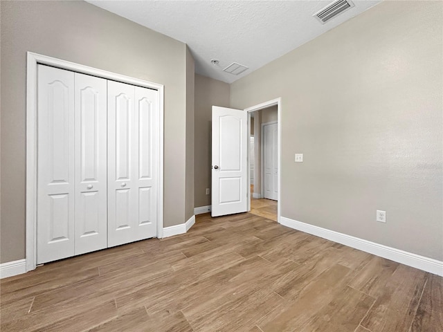 4079 Pacente Loop, Wesley Chapel, FL 33543 - unfurnished bedroom with light wood finished floors and a closet