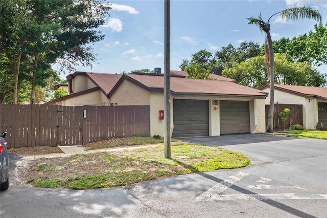 2095 Sunset Point Rd Unit 2201, Clearwater, FL 33765 - view of front of house with stucco siding, an attached garage, and driveway
