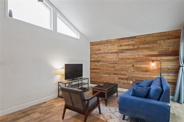 2095 Sunset Point Rd Unit 2201, Clearwater, FL 33765 - living room featuring wooden walls, high vaulted ceiling, wood finished floors, and a textured ceiling