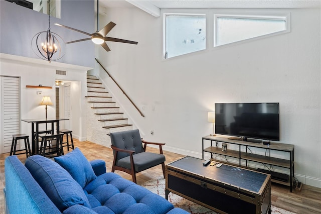 2095 Sunset Point Rd Unit 2201, Clearwater, FL 33765 - living room with a high ceiling, healthy amount of natural light, stairs, a ceiling fan, and wood finished floors