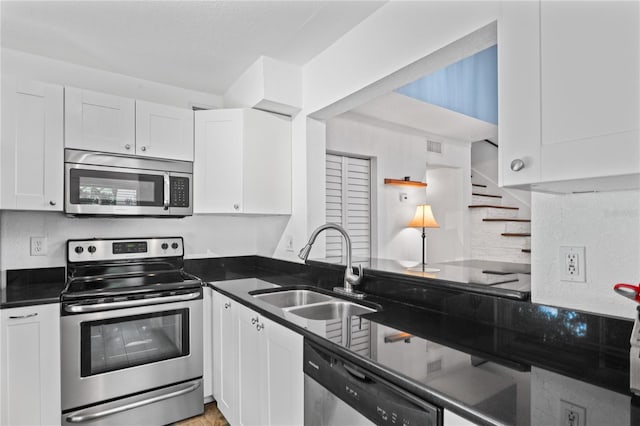 2095 Sunset Point Rd Unit 2201, Clearwater, FL 33765 - kitchen featuring appliances with stainless steel finishes, white cabinets, and tasteful backsplash