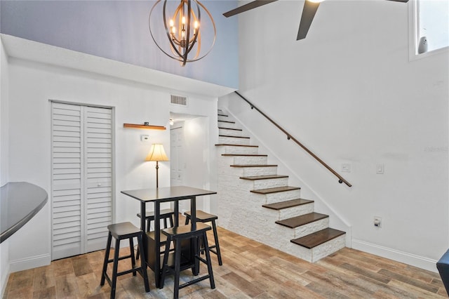 2095 Sunset Point Rd Unit 2201, Clearwater, FL 33765 - dining space with stairway, wood finished floors, a towering ceiling, a chandelier, and ceiling fan