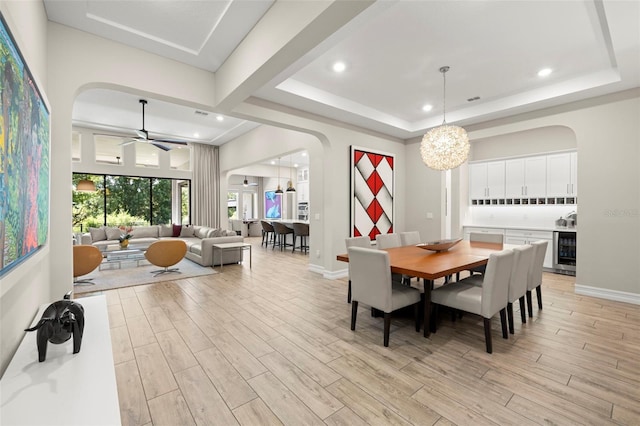 2839 Cordoba Ranch Blvd, Lutz, FL 33559 - dining area with arched walkways, beverage cooler, light wood-style flooring, a tray ceiling, and recessed lighting