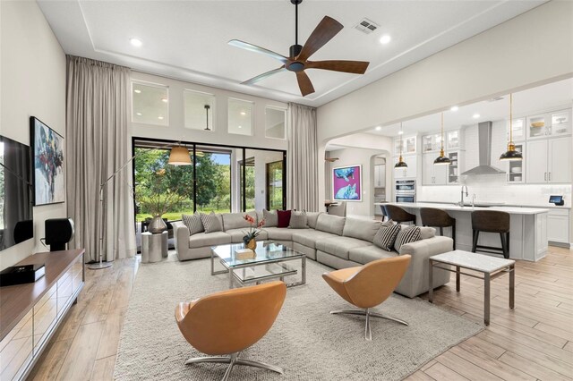 2839 Cordoba Ranch Blvd, Lutz, FL 33559 - living room featuring a ceiling fan, a towering ceiling, arched walkways, light wood finished floors, and recessed lighting
