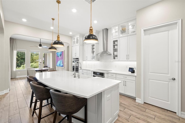 2839 Cordoba Ranch Blvd, Lutz, FL 33559 - kitchen with wall chimney exhaust hood, arched walkways, wood tiled floors, tasteful backsplash, and a breakfast bar