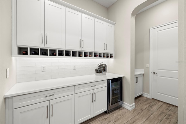 2839 Cordoba Ranch Blvd, Lutz, FL 33559 - bar featuring beverage cooler, backsplash, light wood-style flooring, and arched walkways
