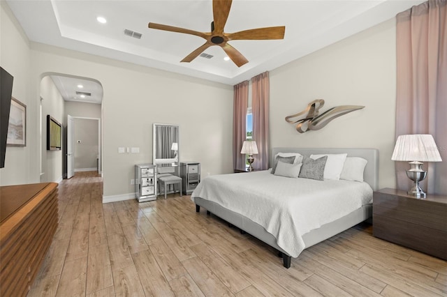 2839 Cordoba Ranch Blvd, Lutz, FL 33559 - bedroom featuring a tray ceiling, light wood finished floors, recessed lighting, ceiling fan, and arched walkways