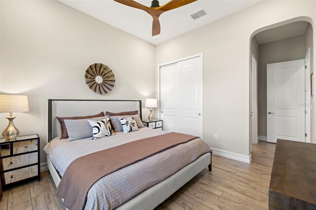 2839 Cordoba Ranch Blvd, Lutz, FL 33559 - bedroom with arched walkways, light wood-style flooring, a closet, and a ceiling fan